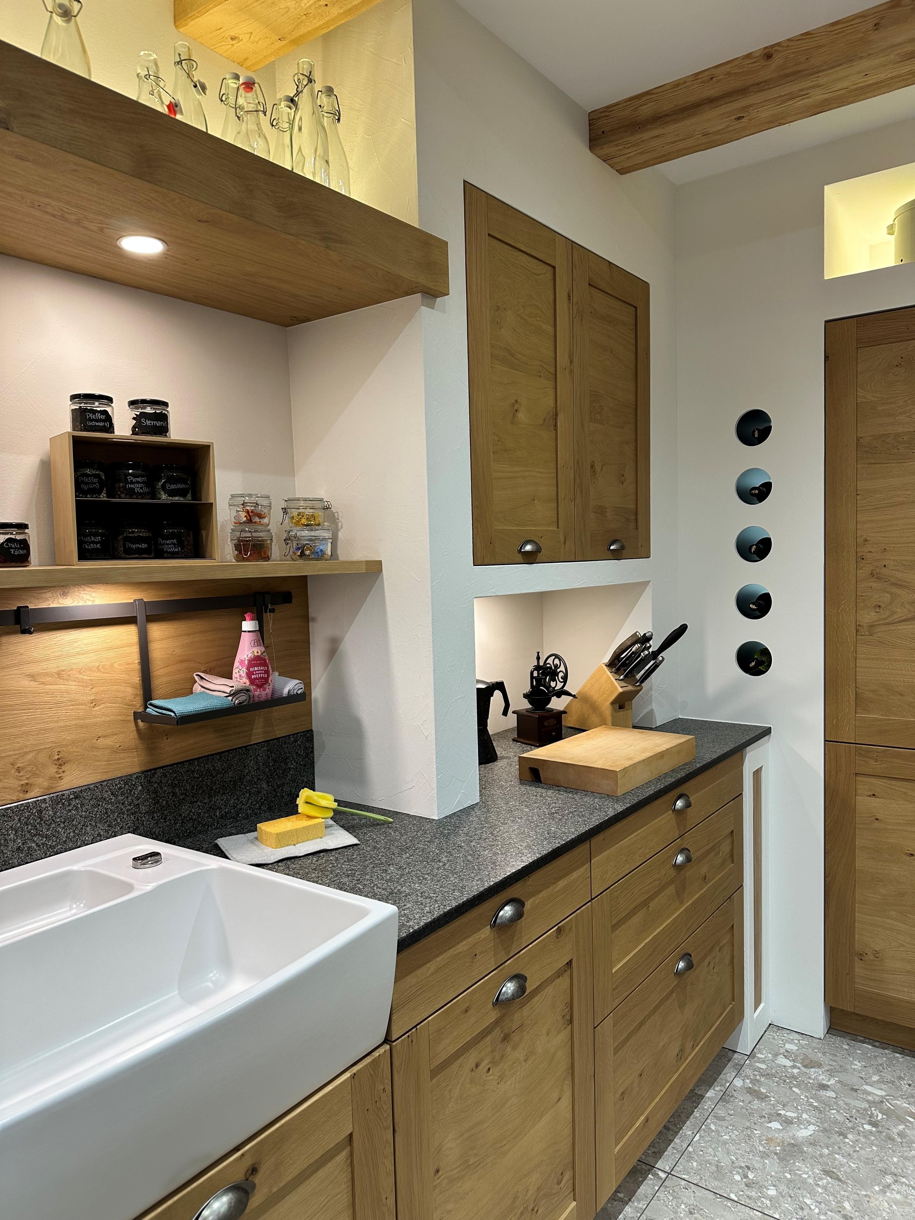 Schöne Landhausküche in Holzoptik mit einem weißen Spülstein. 