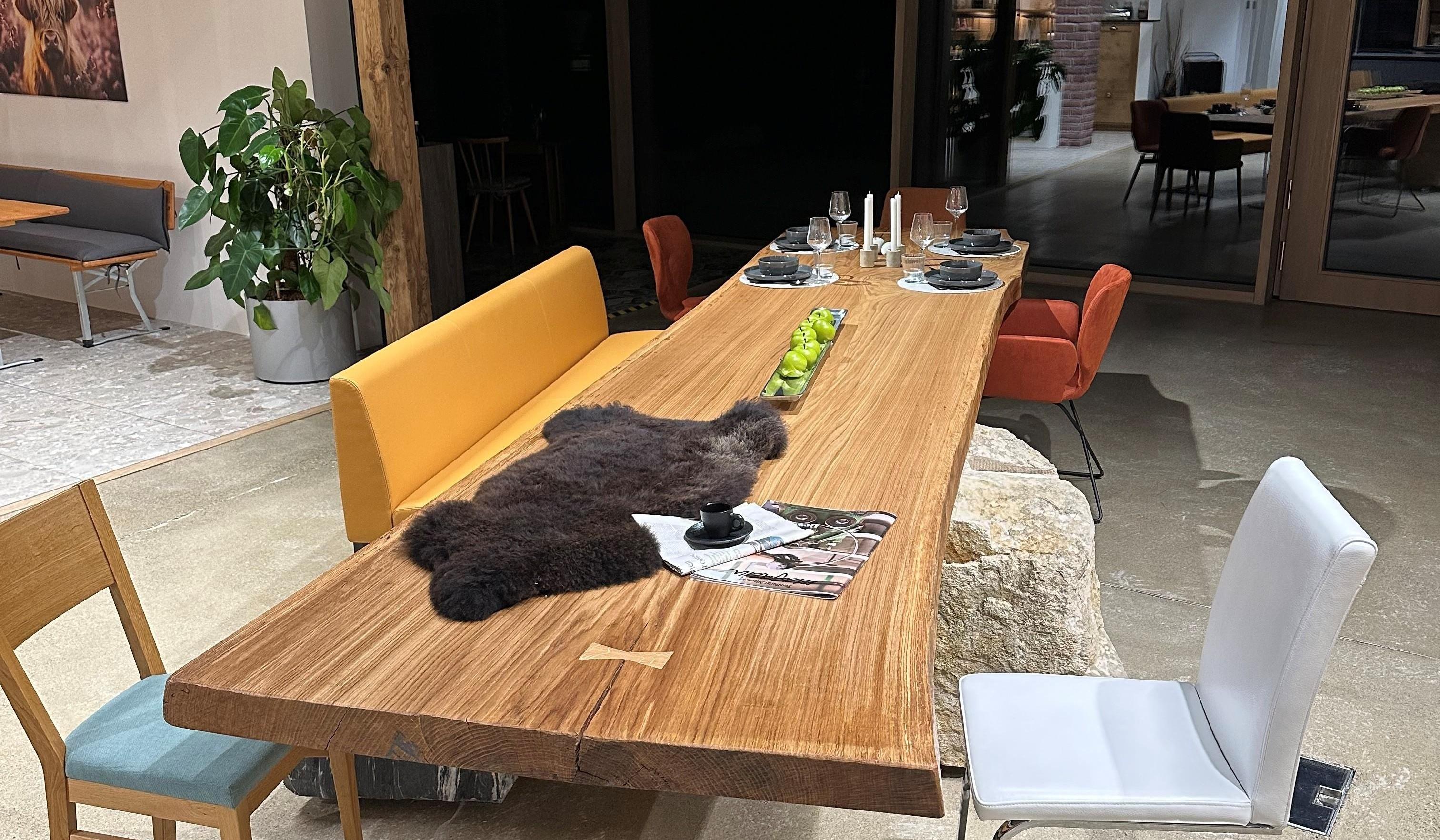 Großes Holztisch mit einer Auswahl an verschiedenen Stühlen. 