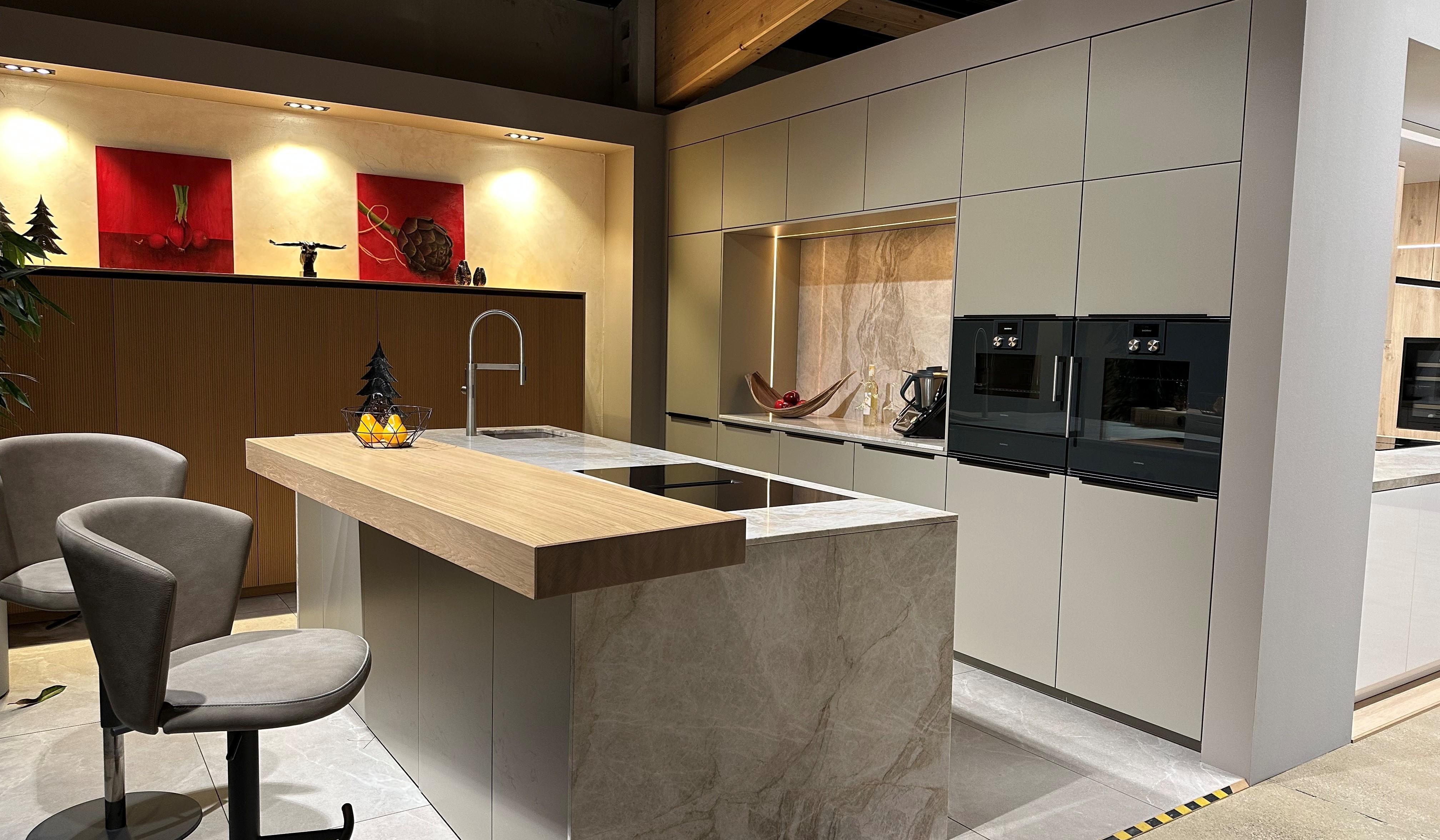 Moderne Küche mit marmorierten Akzenten und einer Kücheninsel mit Theke und Barstühlen. 